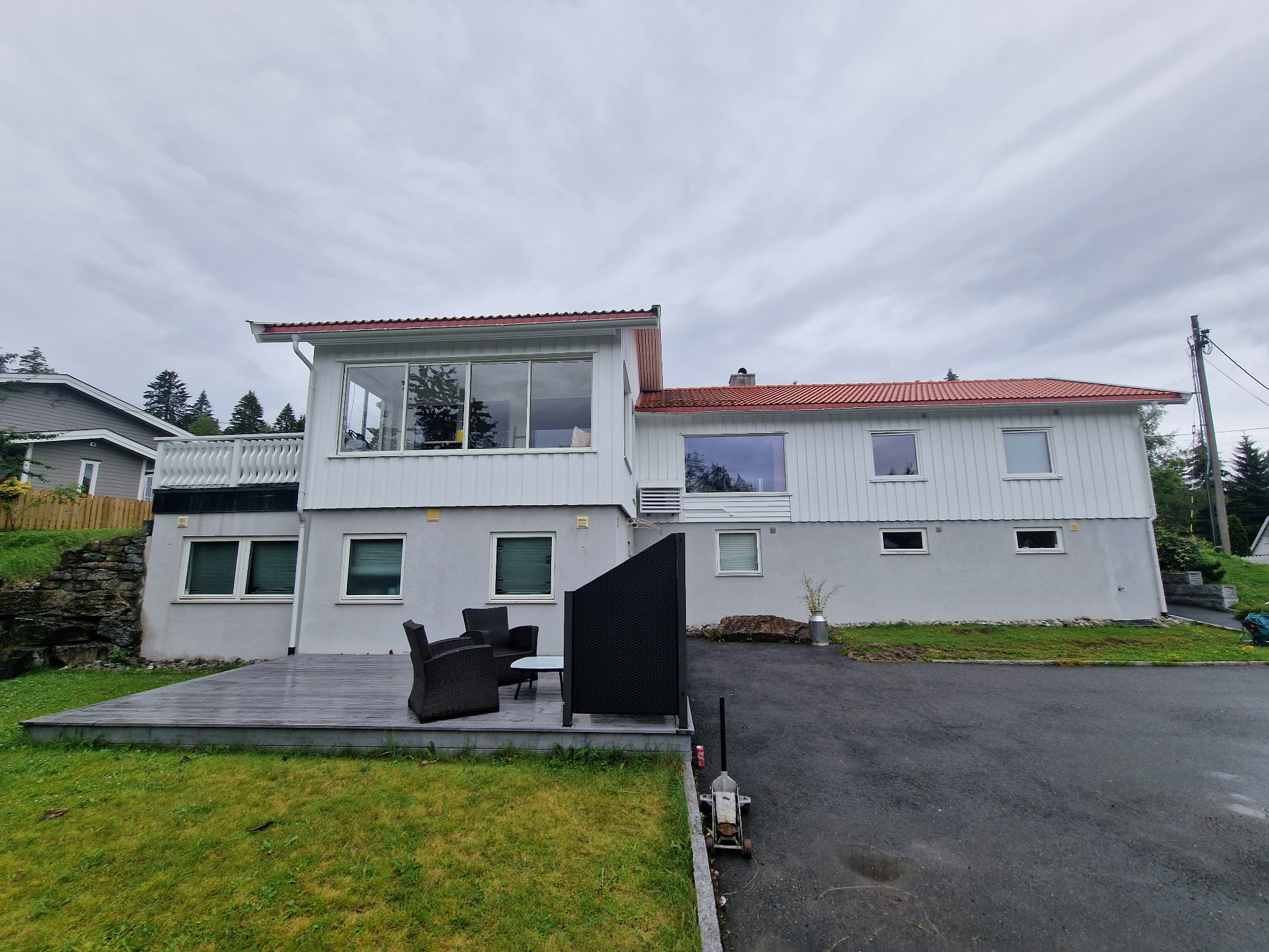 Hvit enebolig med veranda etter rehabilitering